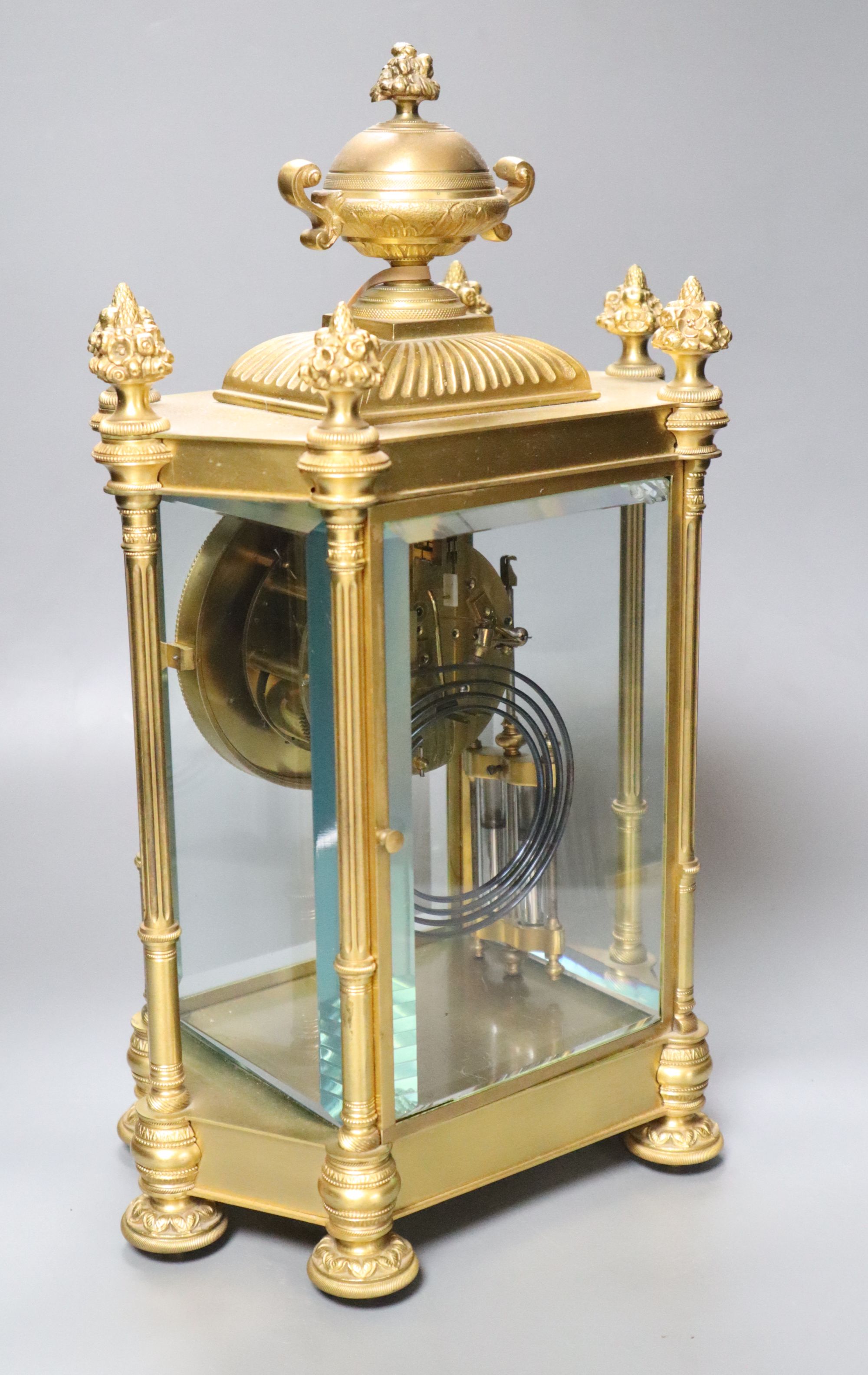 A late 19th century French garniture de cheminée comprising a four-glass mantel clock and a pair of vases